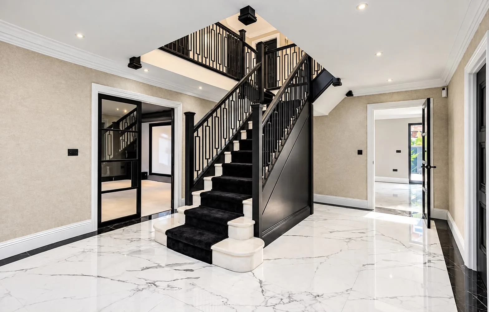 Entrance hallway with a black staircase and marble floor