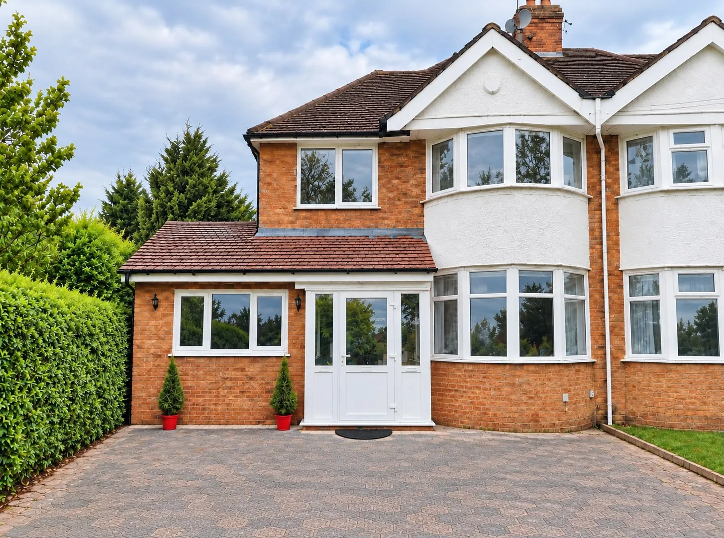 Semi-detached house with a new front porch extension and paved driveway