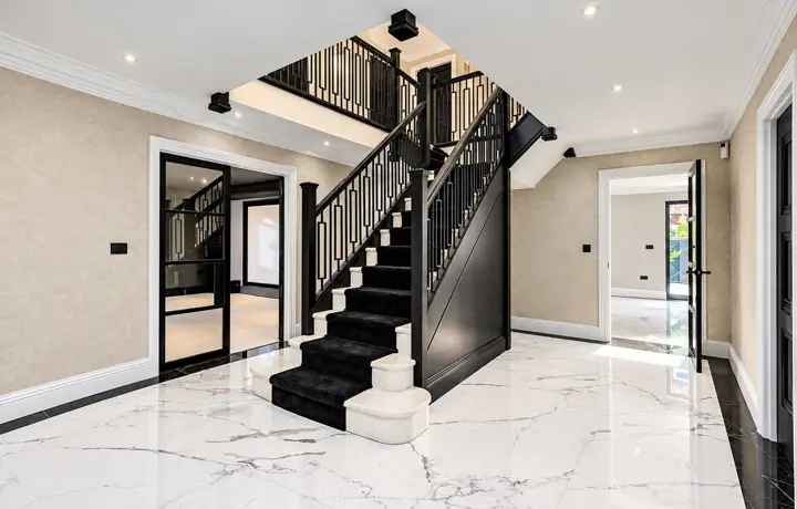 Entrance hall with a black staircase and marble floor