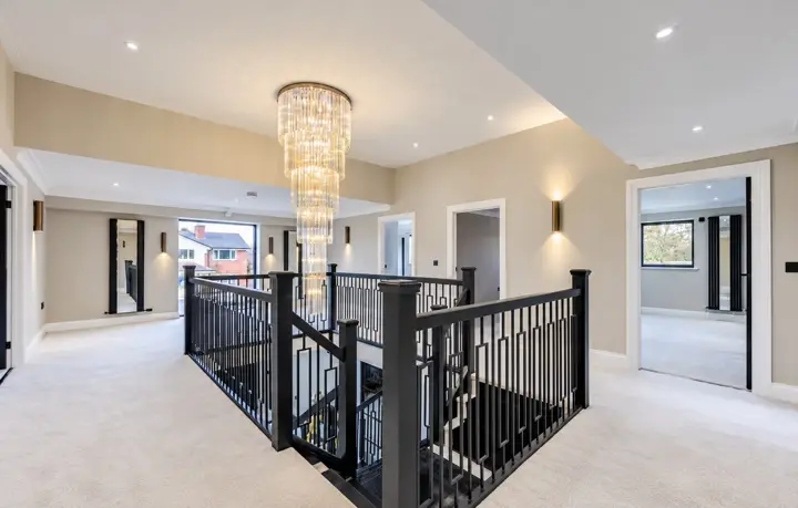 Landing with a chandelier and black balustrade